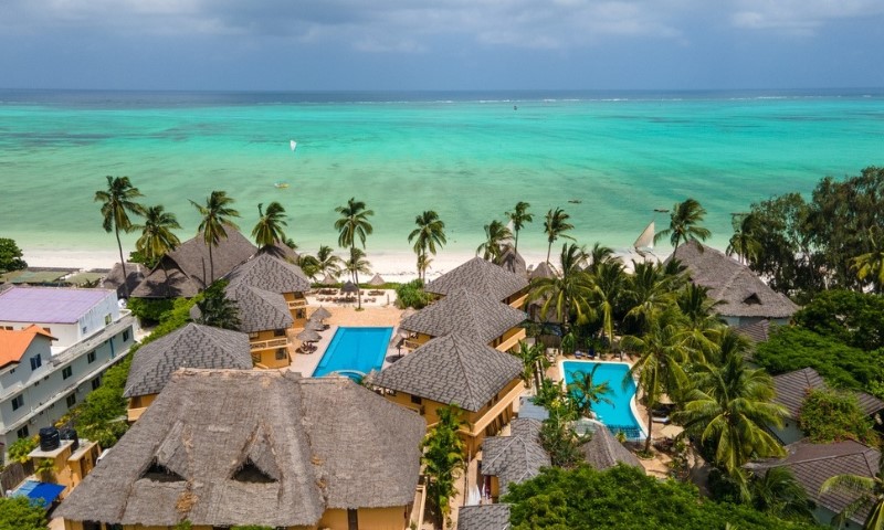 Pogled iz vazduha na tropsko odmaralište na Zanzibaru, sa bungalovima sa slamnatim krovom i bazenima