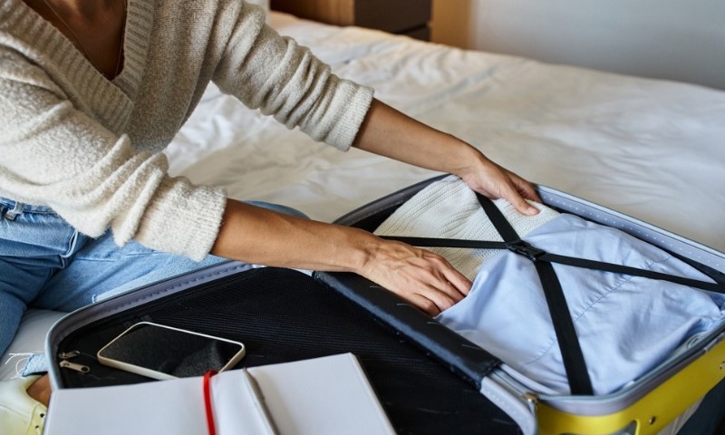 Žena raspakuje svoj prtljag u hotelskoj sobi